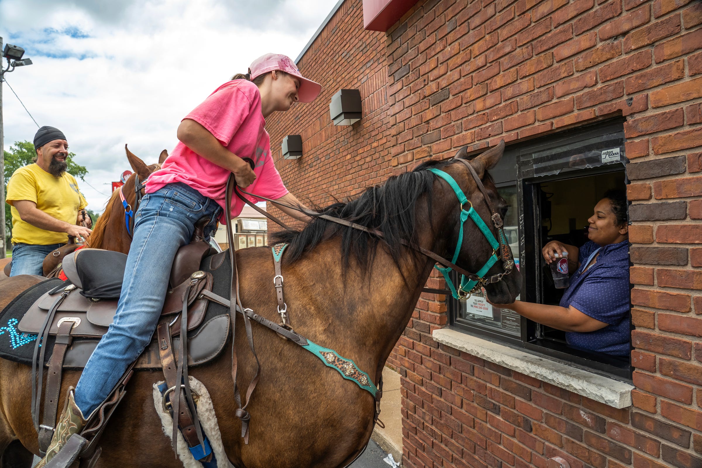 Steven Pringle, owner of Build a Bicycle - Bicycle Therapy, and his girlfriend Lindsey Gagne, of Kingsford go through a fast food drive-thru with their horses Andy and Tucker in downtown Iron Mountain on Friday, July 29, 2022, in Michigan's Upper Peninsula.