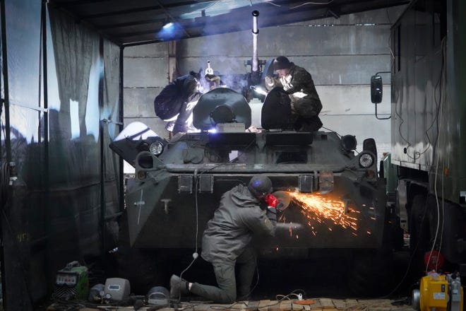 Ukrainian National Guard soldiers repair a captured Russian armored personnel carrier near Kharkiv, Ukraine, on Nov. 3, 2022.