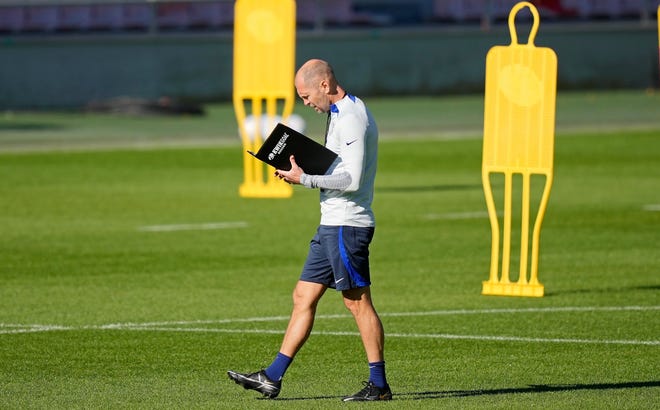 United States coach Gregg Berhalter looks in a book during a training session in Cologne, Germany, September 22.