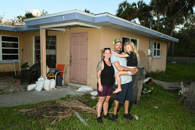 Jessica and Rusty Foltz pose with their daughter Olivia, 6, in front of the Myakka Drive rental home they lived in prior to Hurricane Ian.