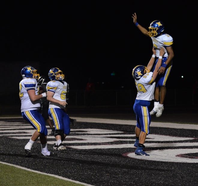 West Muskingum's Kaiden Fleming (59) lifts up Rashid Sesay after his TD in the third quarter of Friday's game at Harvest Prep. It brought the Tornadoes within 26-16, but the Warriors scored 21 straight in earning a 47-16 victory in the Division V, Region 19 playoff contest.