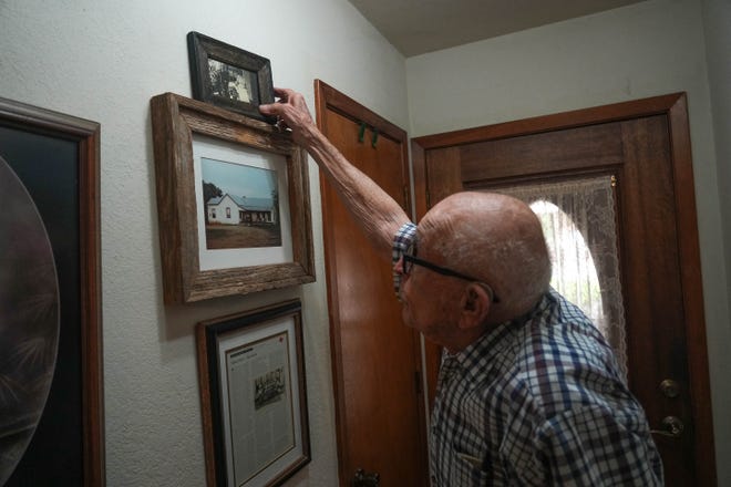 Word War II veteran Archie Moczygemba grabs a photo of his grandparents off the wall in his home in Taylor. Moczygemba was among the first U.S. Marines to enter Nagasaki in 1945 after it was hit with an atomic bomb.
