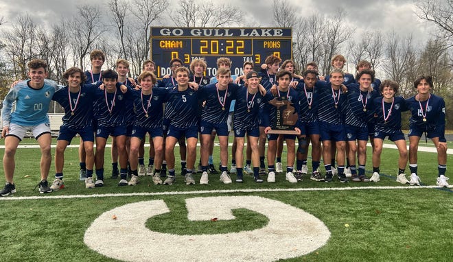 The 2022 Gull Lake boys soccer team with its Division 2 state championship trophy after returning to its home field to celebrate following the state title game.
