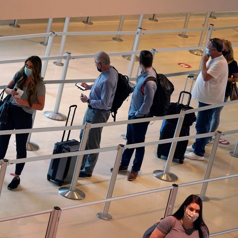 Travelers wait to clear the security check point a