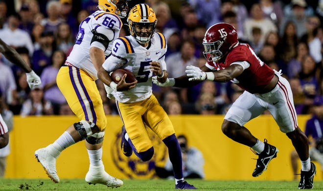 LSU quarterback Jayden Daniels (5) wordt in de pocket gepikt door Alabama linebacker Dallas Turner (15) tijdens de eerste helft in Tiger Stadium.