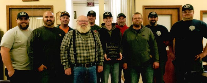 Members of the Litchfield Fire Department pose for a photograph with a plaque they received during a supper in October.