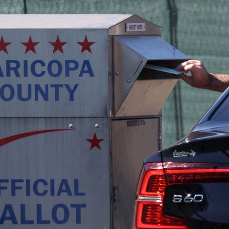 A voter drops their ballot into a drop box outside of the Maricopa County Tabulation and Election Center on Nov. 6, 2022 in Phoenix. With two days to go until election day, early voting continues as Arizona voters are preparing for close midterm election races.