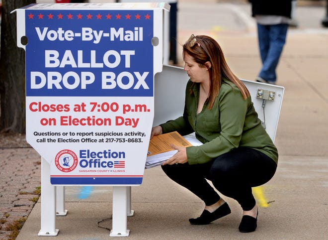 Election Judge Samantha Judd empties the ballot drop box on Monroe Street next to the Sangamon County Complex Tuesday Nov. 8, 2022. She said they have been emptying the box almost every hour.