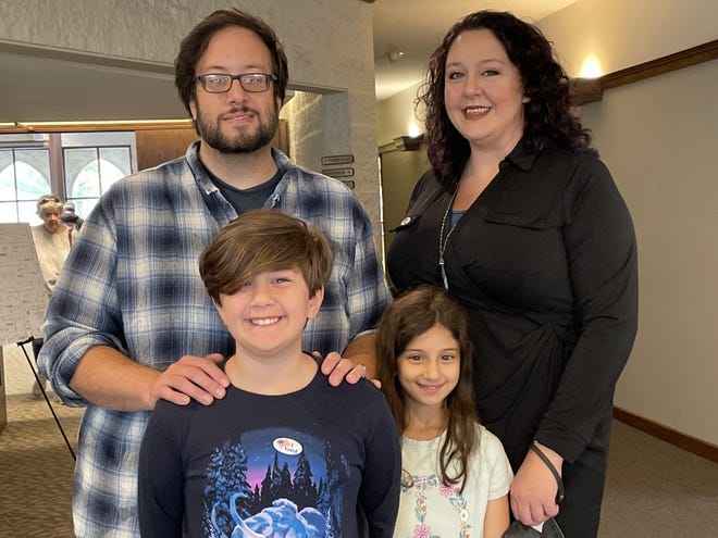 Amber and Tony Lozzi and their children, Henry and Aurelia, stand in the main lobby of Westminster Presbyterian Church after voting Tuesday..