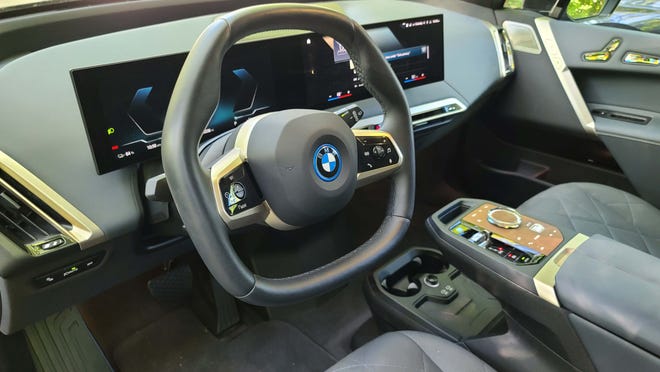 The 2023 BMW iX M60 has a hexagonal steering wheel to better view the big instrument display.