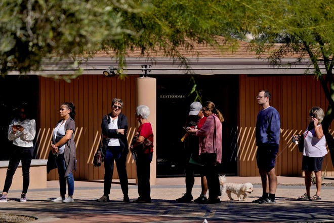 Voters wait in line outside a polling station on  Nov. 8, 2022, in Tempe, Ariz.