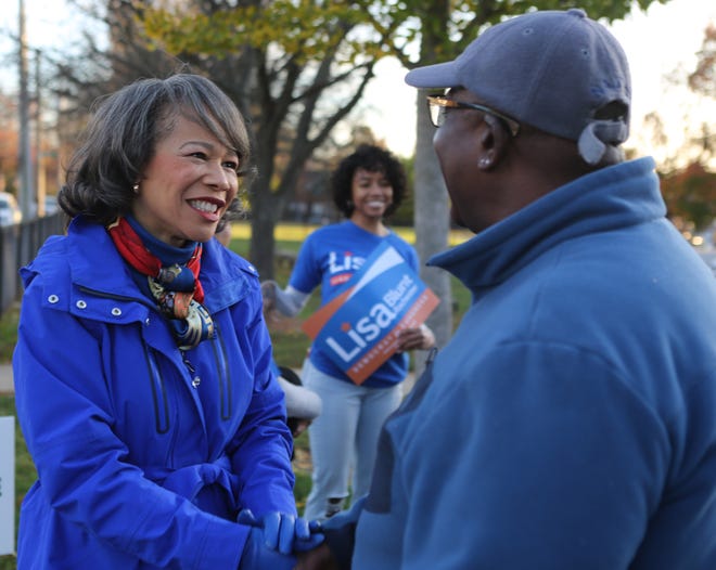 U.S. Congresswoman Lisa Blunt Rochester (left) shakes hands with Randell Knight (right) outside of a polling site in Wilmington.