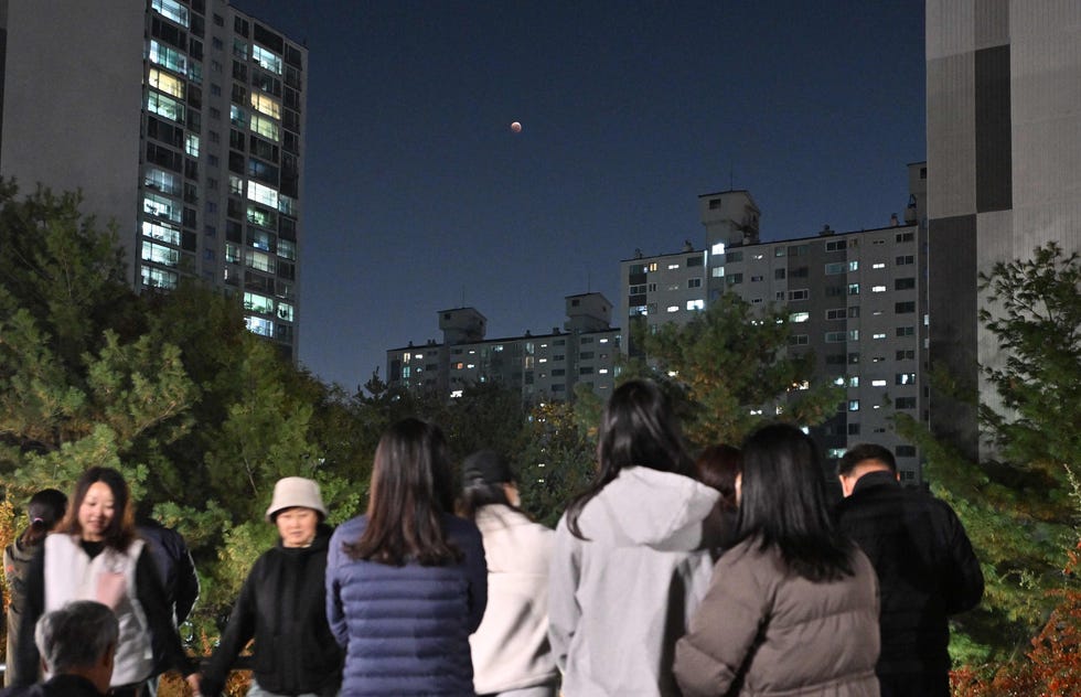 People watch a blood moon during a total lunar eclipse in Goyang, northwest of Seoul, on Nov. 8, 2022.