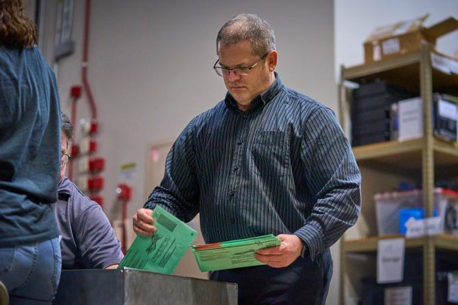 Verkiezingswerkers verspreiden stembiljetten per post voor verwerking in het Maricopa County Tabulation and Election Center in Phoenix, 8 november 2022. Provincieambtenaren noemden dit proces. "Rode lijn Blauwe lijn."
