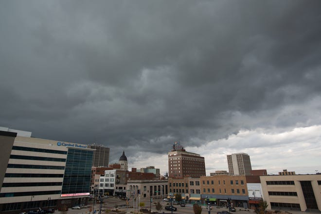 Dark clouds loom over Downtown Topeka on Thursday morning as a cold front brings with it a drop in temperatures.