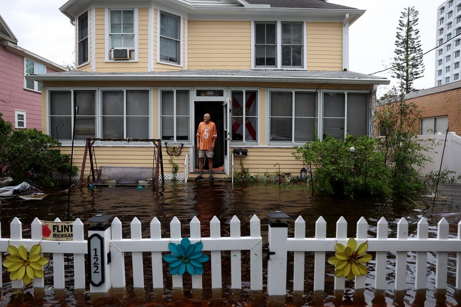 Dale laJeunesse stands in front of his home which is surrounded by flood water after Hurricane Nicole came ashore on November 10, 2022 in Daytona Beach, Florida.