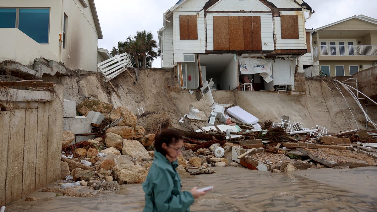 Homes are partially toppled onto the beach after Hurricane Nicole came ashore in Daytona Beach, Florida.