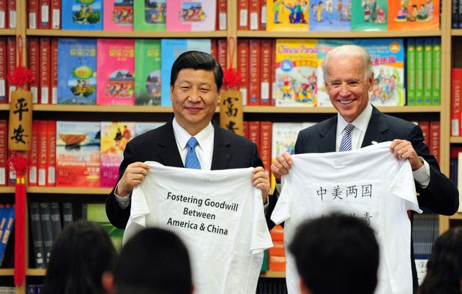 Op deze foto van 17 februari 2012, gemaakt tijdens de ambtstermijn van vice-president Joe Biden, tonen hij en zijn Chinese tegenhanger Xi Jinping T-shirts met een bericht van studenten van de International Studies Learning School in Southgate, buiten Los Angeles.