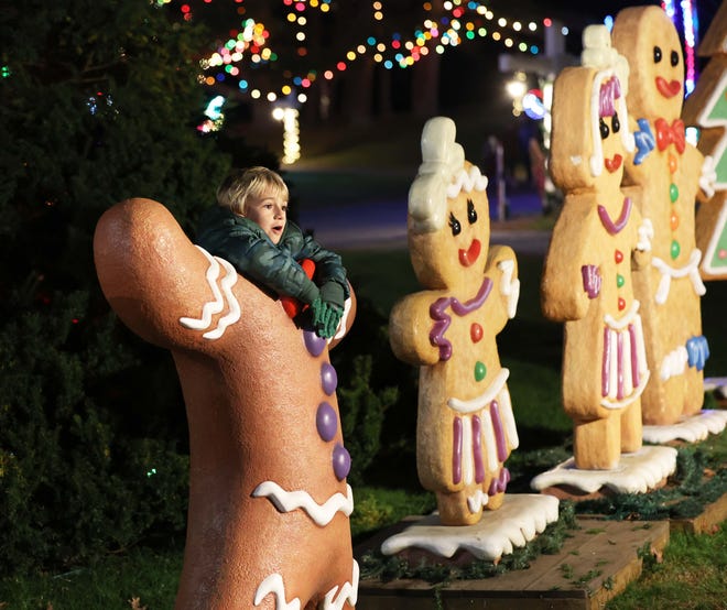 Michael Ferria, 7, of Huntington Beach, California, takes a photograph with gingerbread cutouts during Edaville's Christmas Festival of Lights on Thursday, Nov. 10, 2022, at Edaville Family Theme Park in Carver.