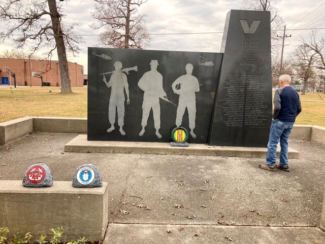 A man reads to roll of Delaware County Vietnam War dead on the black granite Vietnam Veteran Memorial in Heekin Park on Veterans Day.