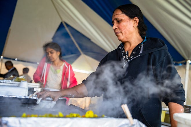 Les membres du personnel de Pavani Express travaillent pour servir une ligne de restauration animée avec des dosas, des samoussas et plus encore au Festival de l'Inde au temple Sri Venkateswara à Corpus Christi, Texas, le samedi 12 novembre 2022.