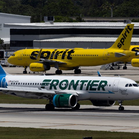 A Frontier Airlines plane near a Spirit Airlines p