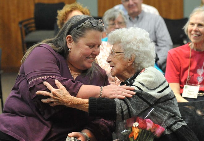 Lorraine Musico, from North Weymouth, right, shares a moment with her granddaughter Tracy Handrahan, from Plymouth, left, during her 100th birthday party at the South Shore Genealogical Society meeting at the John Curtis Free Library in Hanover, on Saturday, November 12, 2022.
