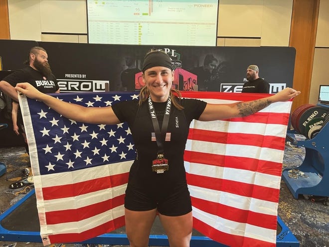 Maddy Haberling holds an American flag after winning gold in the women's 67.5kg open at the International Powerlifting League Drug Tested World Championship in Gold Coast, Australia, on Friday, Nov. 4, 2022. Haberling is a native of Marysville.