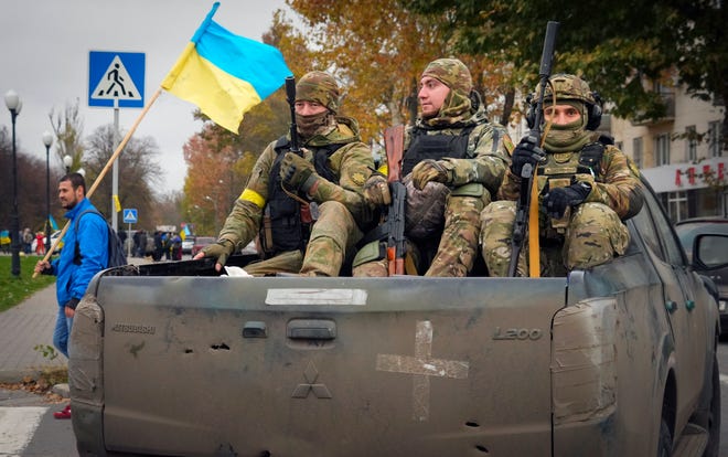 Украинские солдаты сидят в пикапе в Херсоне, центральная Украина, воскресенье, 13 ноября 2022 г.