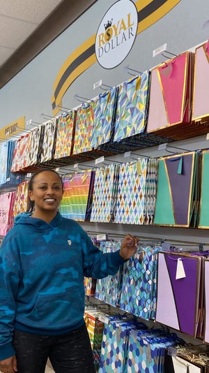 Damme Woldetsadik, manager of Royal Dollar at 7841 Refugee Road in Violet Township, shows off some of the merchandise offered at the store, which opened Oct. 19. Most items in the store are $5 or less.