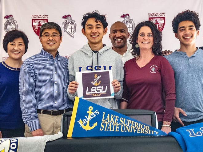 Harbor Light Christian senior Yongbo 'Raymond' Guan (middle) recently signed with the Lake Superior State men's golf program. He was joined by his aunt and uncle, Xiaocong Guan and Jun Li (left) and host parents, William and Holly Henagan (right).