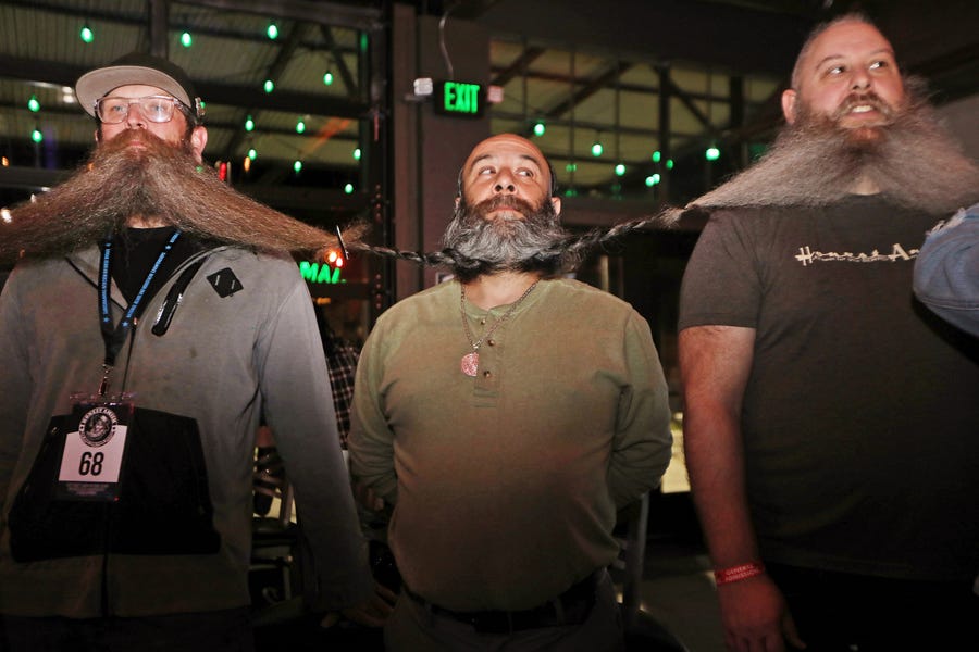 Men wait for the chain of their beards to be measured as part of their attempt at breaking the world's longest beard chain in the Guinness Book of World Records, Friday, Nov. 11, 2022, at The Gaslight Social in Casper, Wyo.