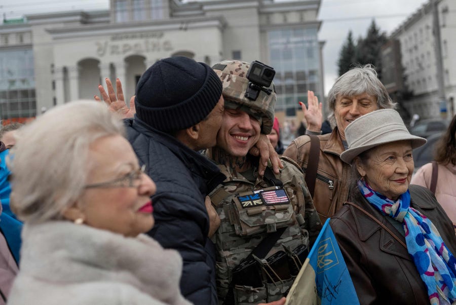 A man hugs a Ukrainian soldier as local residents gather to celebrate the liberation of Kherson, on November 13, 2022, amid Russia's invasion of Ukraine.