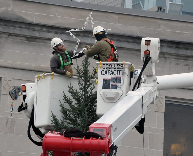 Workers from AEP put the star on top of the Christmas tree on the square in Wooster ahead of Friday's tree lighting and arrival of Santa.