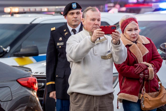 The remains of Lt. John Heffernan, a World War II American bomber navigator who was shot down in Burma in 1944, arrive at Newark Liberty Airport Tuesday, Nov. 15, 2022. Andrew McVeigh (center), the nephew of Heffernan, documents the finish on his phone as his wife Amy McVeigh (right) looks on.