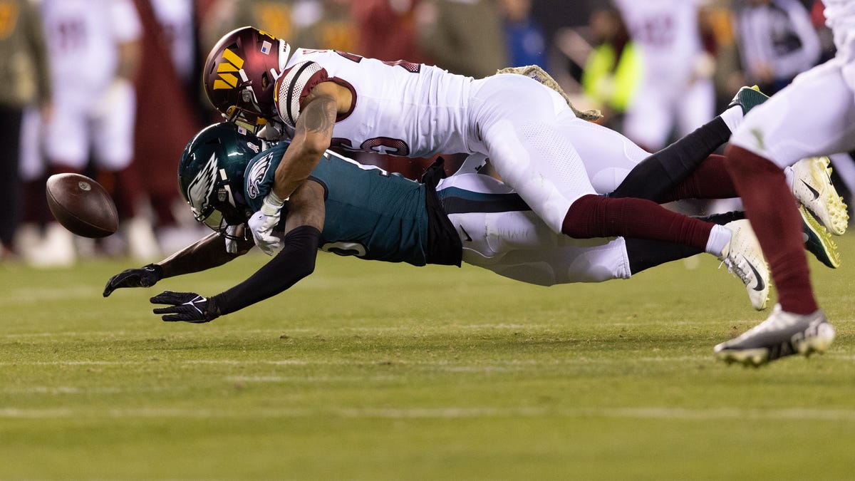 Philadelphia Eagles wide receiver Quez Watkins fumbles the ball while being tackled by Washington Commanders safety Darrick Forrest.