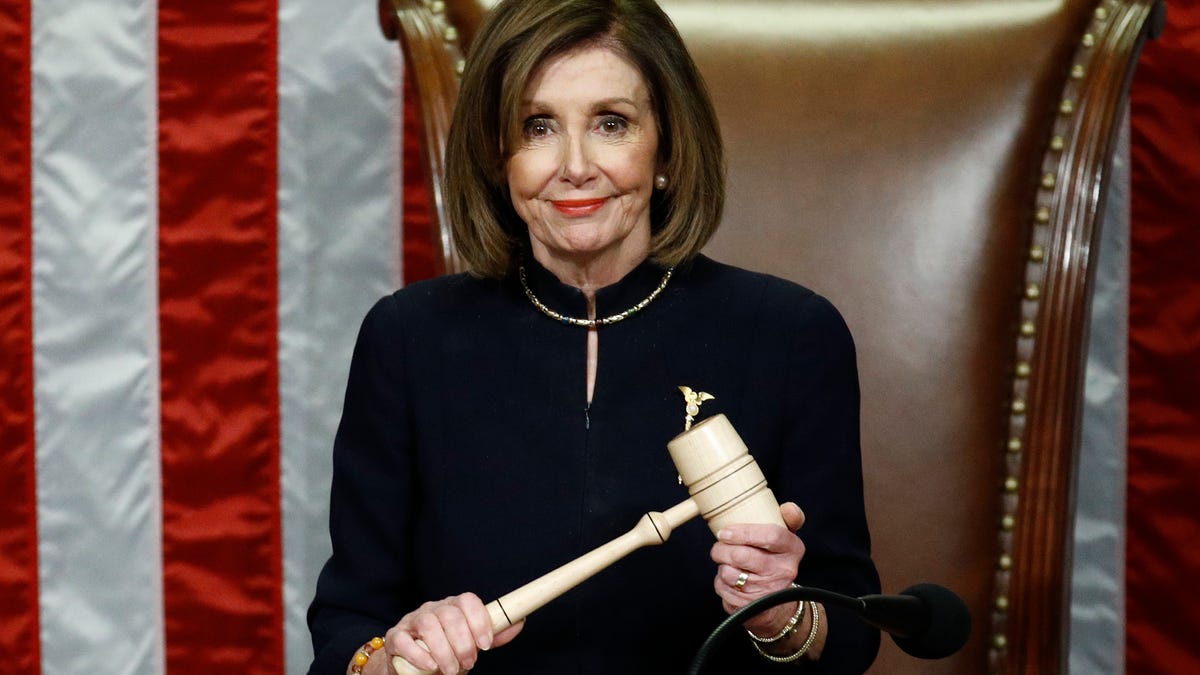 House Speaker Nancy Pelosi of California smiles as she holds the gavel as the House votes on articles of impeachment against President Donald Trump on Dec. 18, 2019.