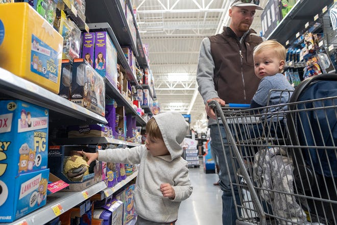 Layson Collins, 2, picks out a toy alongside his father, Chandler Collins, and brother, Daxsyn Collins, 1, as they shop for early Black Friday deals at the Walmart on Whitestone Boulevard in Cedar Park on Nov. 16. Walmart is offering Black Friday deals throughout November.