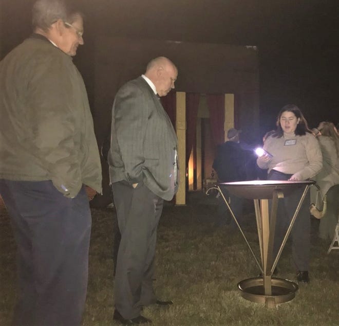 Marv Evans, left, and Dexter Joyner listen as a student volunteer explains the bronze laver, a wash bowl situated outside the temple in the Tabernacle.