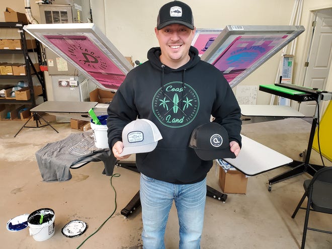 Jason Pardue, owner and founder of Lexington-based Coastland Apparel, holds two of his company's most popular hats. He started the company in his bedroom and has moved it five times as the business has grown.