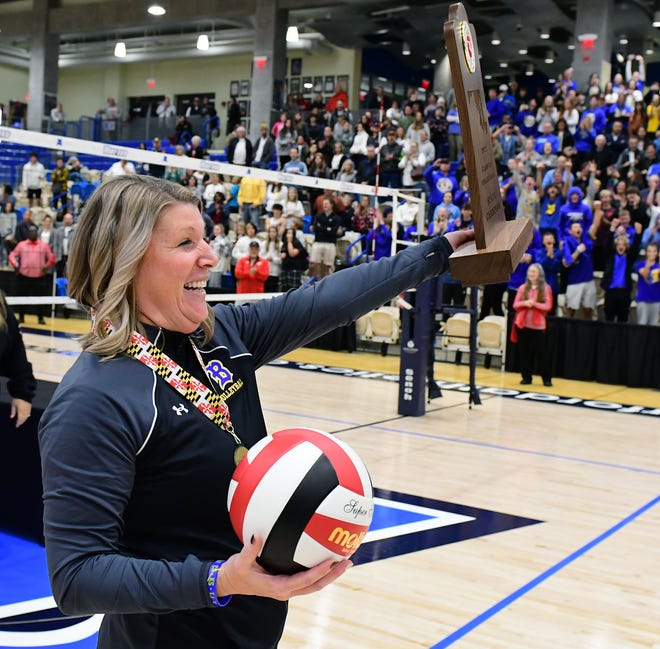 Clear Spring volleyball coach Jessica Custer carries the Maryland Class 1A state volleyball championship trophy to the players after they swept South Carroll at Harford Community College.