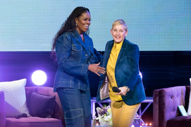 Former first lady Michelle Obama greets Ellen DeGenereson stage as she launches her new book “The Light We Carry: Overcoming in Uncertain Times” at Warner Theater in Washington, Tuesday, Nov.15, 2022.