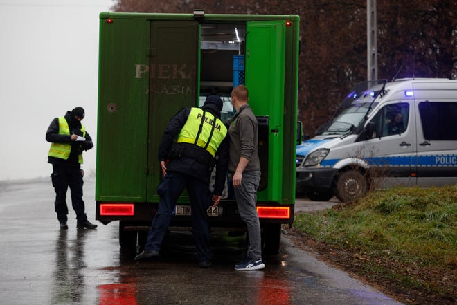 Een politieagent controleert een voertuig buiten een graanmagazijn waar, volgens de Poolse regering, een explosie van een Russische raket mensen heeft gedood, in Przewodow, Polen, woensdag 16 november 2022.