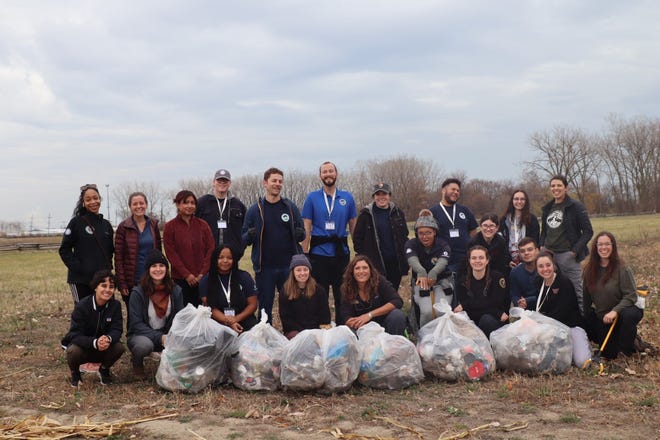 The interns pose with the bags of litter they collected at the River Raisin National Battlefield Park.