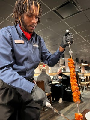 A gaucho serves grilled chicken tableside at Rodizio, a new Brazilian steakhouse in Oklahoma City's Bricktown district.