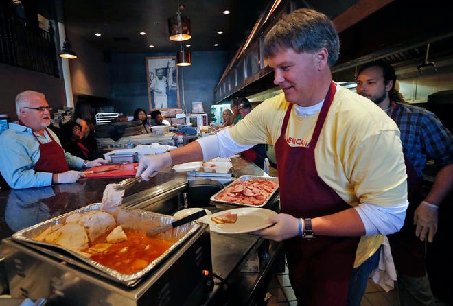 Glen Akins places sliced turkey onto a plate while volunteering during the annual Thanksgiving feast hosted at Chuck's Fish on Greensboro Avenue in downtown Tuscaloosa on Thursday, Nov. 26, 2015. [Staff file photo]