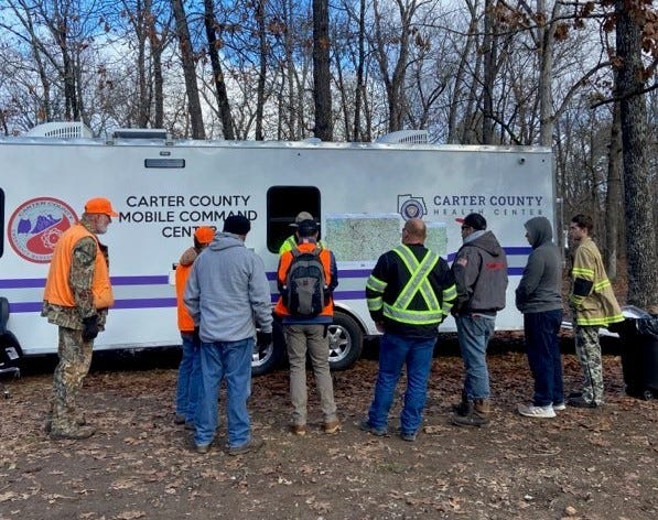 Search volunteers gathered for assignments at the Carter County Mobile Command Center, which was brought to the remote location to serve as a headquarters for the search team.