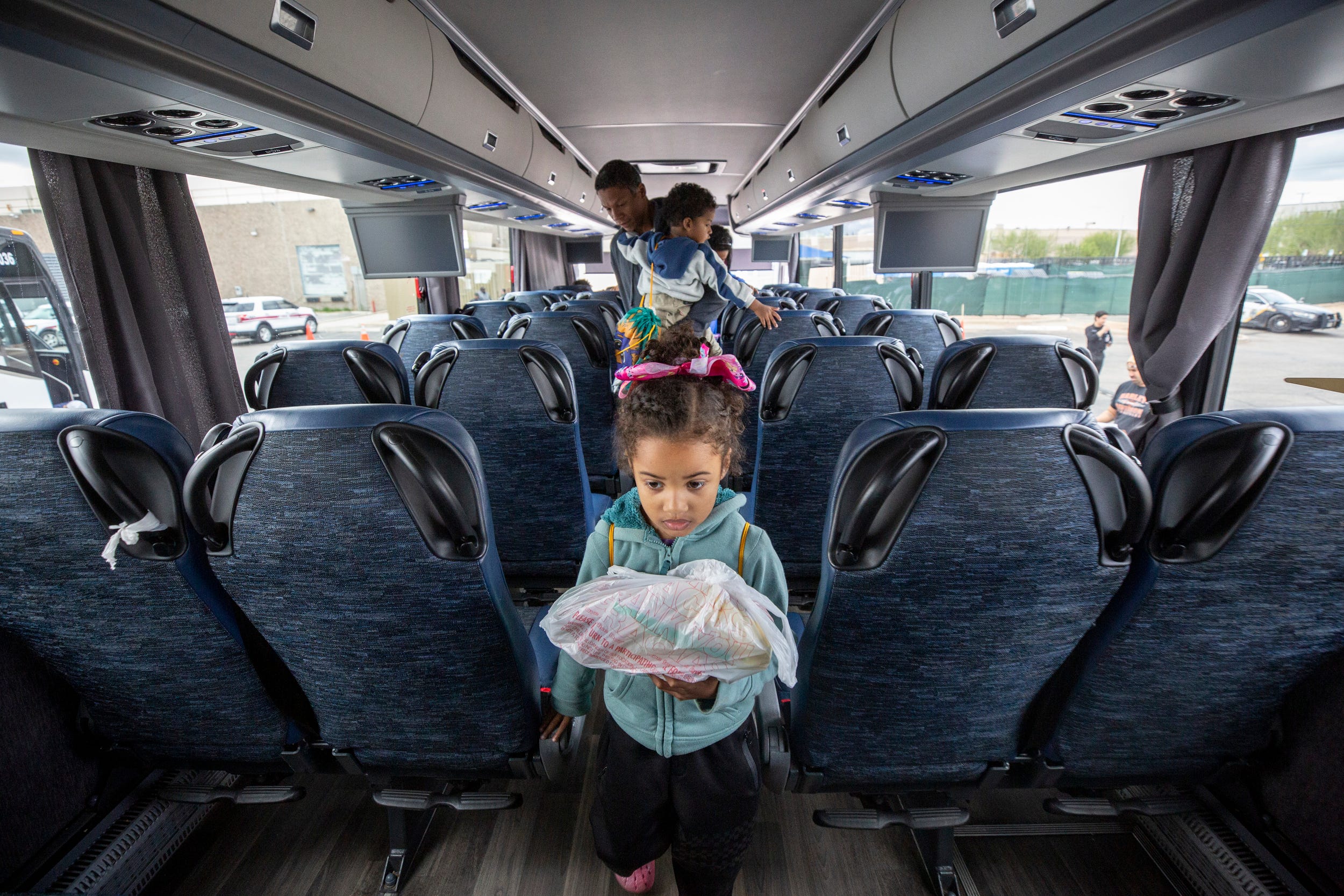 Five-year-old Brittany, the daughter of Kristian Gonzalez Perez and Katiuska Carolina Leal Moreno, boards a bus headed to New York City from the Migrant Welcome Center in El Paso, Texas.
