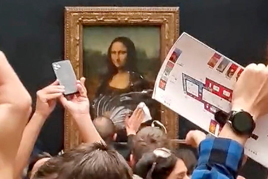 Een bewaker maakt room schoon die is gesmeerd van het glas dat de Mona Lisa beschermt in het Louvre in Parijs nadat een man verkleed als oude vrouw in een rolstoel een fluitje van een cent naar het schilderij gooide, 29 mei, nadat hij had geschreeuwd tegen mensen om aan te denken planeet aarde.