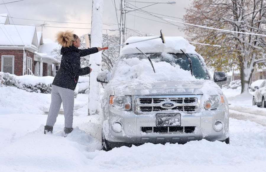 Taylor Olson clears snow from her car in Erie, Pa. after the region saw its first lake-effect storm of the season overnight Wednesday into Thursday, with about five inches of snow in the city.